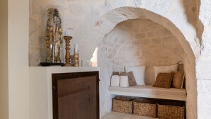A stone archway, a bench with cushions, and wicker baskets. - Villa 'Trulli San Domenico' with Private Pool, Wi-Fi and Air Conditioning (Martina Franca)