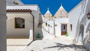 A narrow street with white buildings, a covered area, and a clear blue sky. - Villa 'Trulli San Domenico' with Private Pool, Wi-Fi and Air Conditioning (Martina Franca)