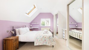 A bedroom with a bed, bedside table, lamp, and a window. - Central Bourton Gem|5 Bedrooms|Garden|Parking - Pass the Keys (Bourton-on-the-Water)