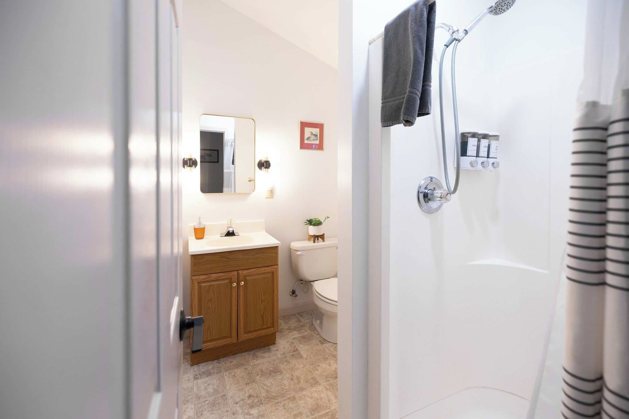 Un baño con ducha, inodoro, lavamanos y armarios de madera.
