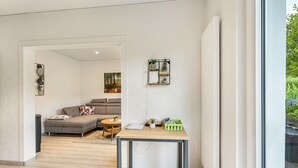 A modern living room with a sofa, coffee table, and a small table with decorative items. - Apartment "Gerke" with Wi-Fi (Warstein)