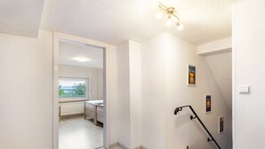 A modern interior with a staircase, a radiator, and a window with a view. - Apartment "Gerke" with Wi-Fi (Warstein)