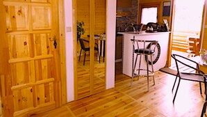 Un intérieur en bois comprenant un coin cuisine, une table à manger avec des chaises et un bar.