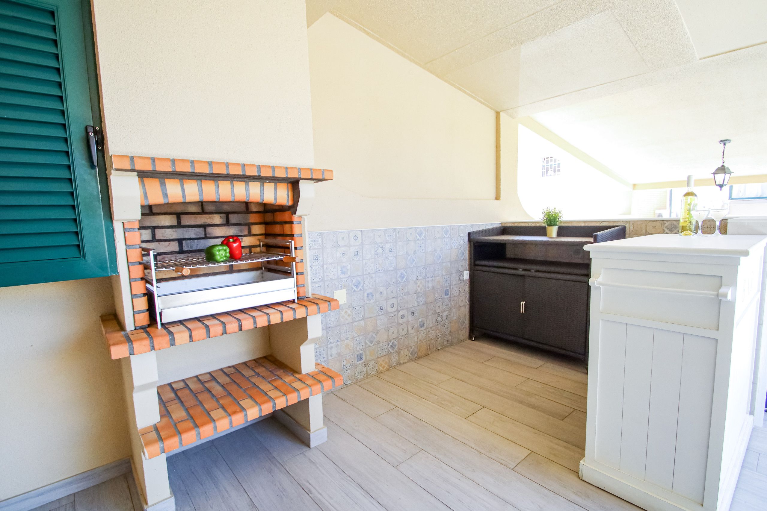 A kitchen with a brick oven, a sink, and a cabinet.