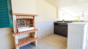 A kitchen with a brick oven, a sink, and a cabinet.