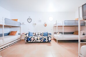 A dormitory room with bunk beds, a patterned sofa, and wall decorations. - Spacious Villa w/ Jacuzzi • Close to the Beach • Free WiFi (Albufeira)