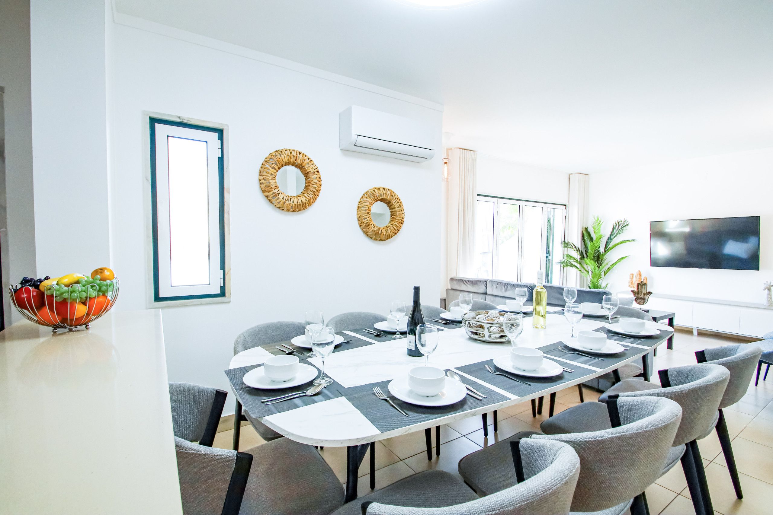 Un comedor con una larga mesa dispuesta para una comida, rodeada de sillas.
