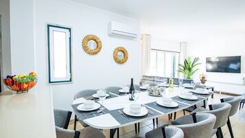 Un comedor con una larga mesa dispuesta para una comida, rodeada de sillas.