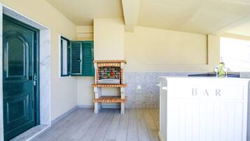 Una cocina con barra, una puerta verde y salpicadero de azulejos.