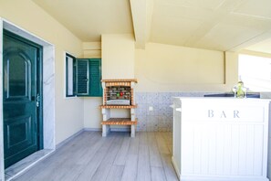 A kitchen with a bar area, a green door, and a tiled backsplash.