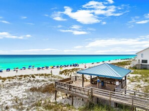 Ein Strand mit einer Holzkonstruktion, blauem Himmel und Sand.