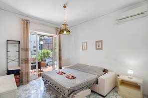 Une chambre à coucher avec un lit, une table de chevet et une vue sur l’extérieur.