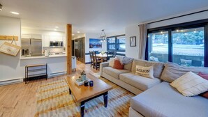 Ein modernes Wohnzimmer mit Sofa, Couchtisch und Essbereich.