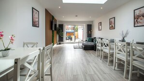 Ein modernes Interieur mit Essbereich, Sofa und Blick durch eine Glastür.