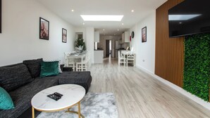 Ein modernes Wohnzimmer mit einer Couch, einem Couchtisch und einem Fernseher.