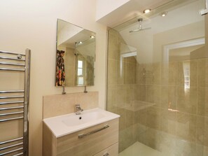A bathroom with a glass shower enclosure, a white sink, and a mirror above it. - Ormiston House (Pewsey)