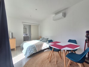 Ein Schlafzimmer mit Bett, Nachttisch und Schreibtisch mit Stuhl.