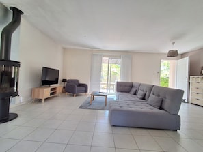 Ein Wohnzimmer mit einer Couch, einem Fernseher und einem Kamin.
