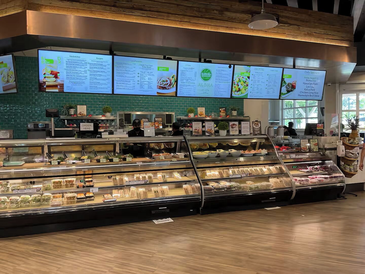 Un comptoir de vente à emporter proposant divers produits alimentaires, avec un tableau affichant le menu au-dessus.