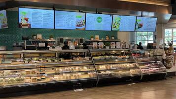 Un comptoir de vente à emporter proposant divers produits alimentaires, avec un tableau affichant le menu au-dessus.