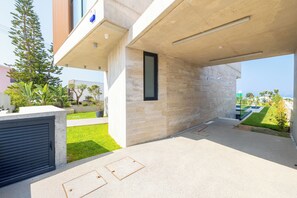 Ein modernes Gebäude mit Betonfassade, einer Garagentür und einem kleinen Fenster.