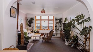Un salon chaleureux avec un canapé, un fauteuil, une table basse et des plantes en pot.