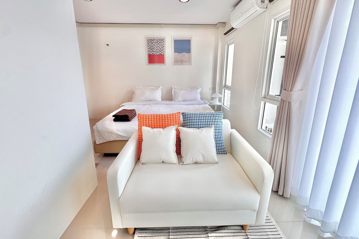 Une chambre moderne équipée d’un lit, d’un canapé et d’un appareil de climatisation.