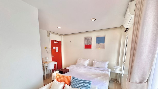 A hotel room with a bed, a desk, a chair, and a sofa. - Boon Poshtel Hatyai (Hat Yai)