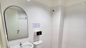 A bathroom with a sink, toilet, and mirror. - Boon Poshtel Hatyai (Hat Yai)