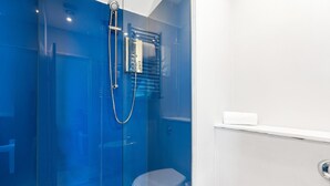 A bathroom with a glass-enclosed shower, a white sink, and a toilet. - Oriental Nine | By My Getaways (Brighton)