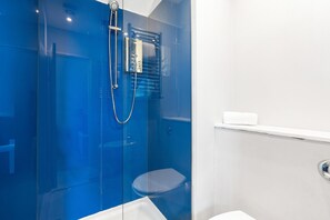 Ein Badezimmer mit Duschkabine, Waschbecken und Toilette.