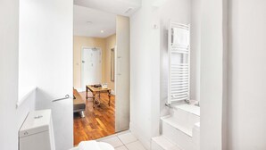 Un baño moderno con inodoro, lavamanos y ducha.