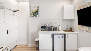 A compact kitchen with a refrigerator, a coffee maker, a toaster, and a sink. - Modern Dockside Apartment | Near Gunwharf Quays (Portsmouth)