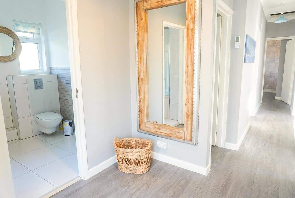 A bathroom with a toilet, a white sink, and a mirror.