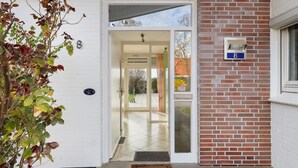 A building entrance with a numbered door, a mailbox, and a small garden area. - Holiday Home for 6 Guests, 150 m², in Winsen (Luhe) with Wi-Fi (Winsen (Luhe))