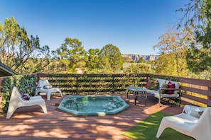 Ein Garten mit Whirlpool, Sitzgelegenheit im Freien und Blick auf Berge.