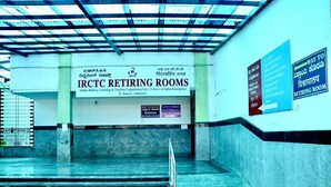 Un pasillo que lleva a las habitaciones de descanso IRCTC, con un cartel que indica el camino a la habitación.
