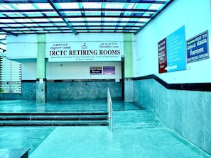 Un pasillo que lleva a las habitaciones de descanso IRCTC, con un cartel que indica el camino a la habitación.