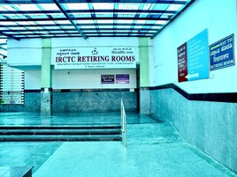 Un pasillo que lleva a las habitaciones de descanso IRCTC, con un cartel que indica el camino a la habitación.