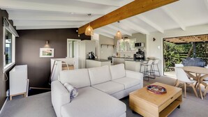 Een moderne woonkamer met een bank, salontafel en een eethoek.