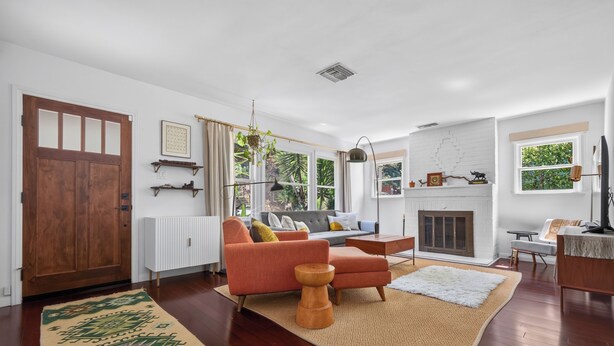 A modern living room with a sofa, armchairs, a fireplace, and a large window. - Beautifully Updated Designer Home near Universal Studios in the Hollywood Hills (Los Angeles)