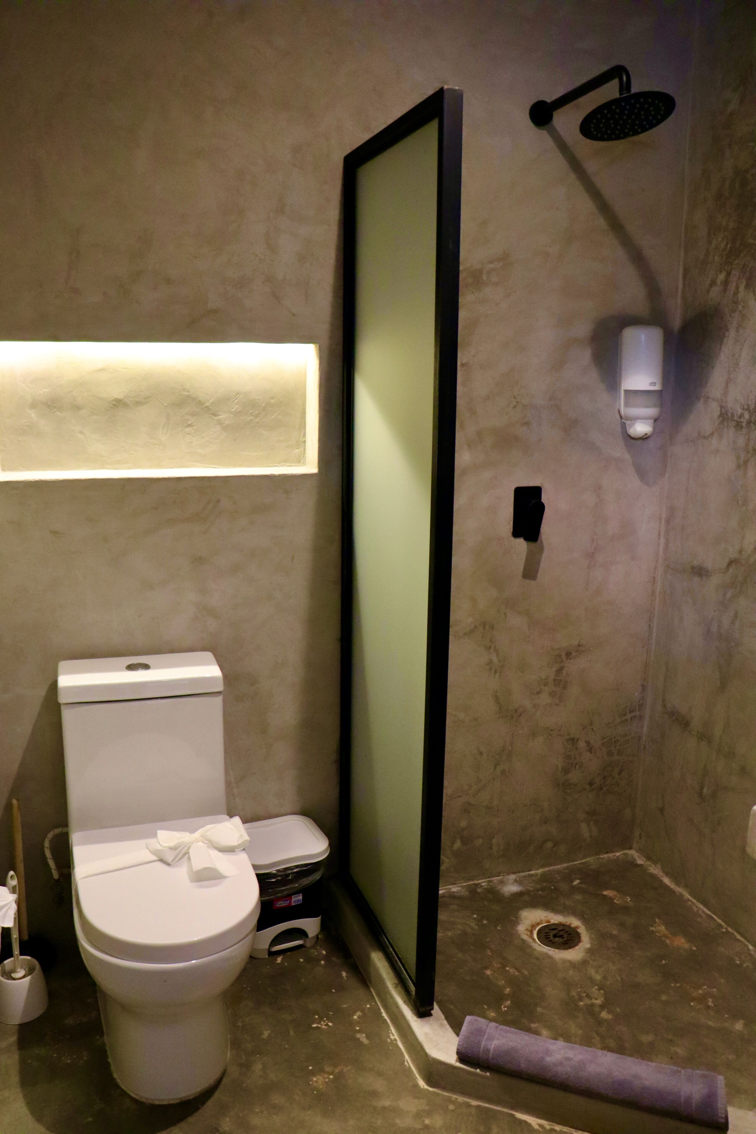 Un baño con inodoro, cabina de ducha y toalla.