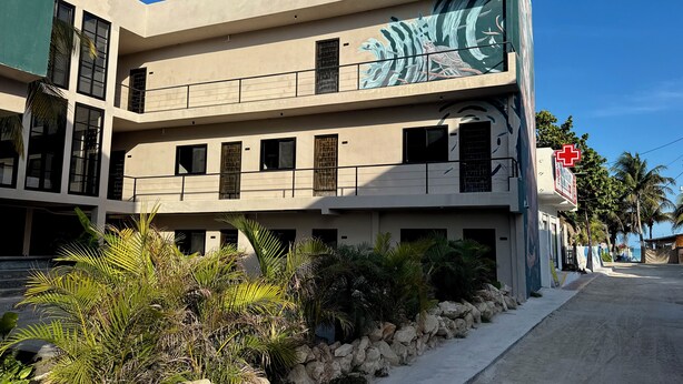 Un edificio de varios pisos con un letrero de centro médico, un balcón y un mural.