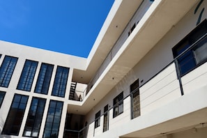 A multi-story building with a modern architectural design, featuring balconies and large windows. - Piscis Art by ÓOL Hotels (Isla Holbox)