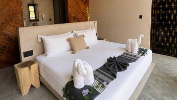 A modern hotel room with a large bed, a wooden headboard, a bedside table, and a decorative wall panel.