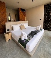 Quarto de hotel moderno com uma cama grande, cabeceira de madeira, mesa de cabeceira e um painel decorativo na parede.
