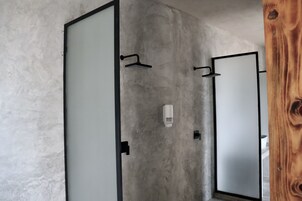Ein Badezimmer mit einer Betonwand, einem Holzrahmen und einem Spiegel.