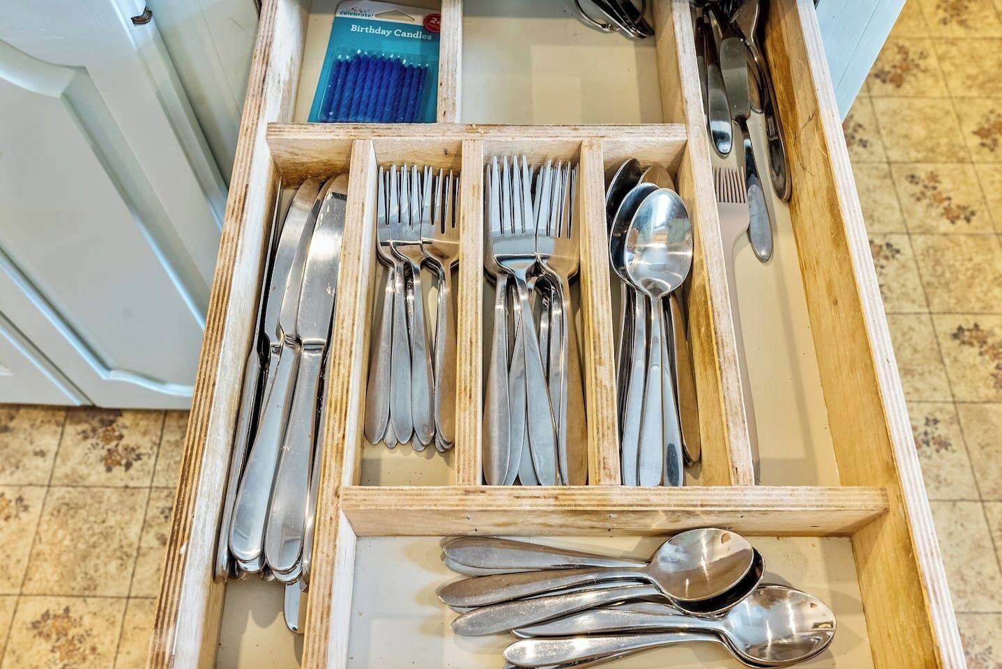 A drawer with neatly organized cutlery including forks, knives, and spoons.