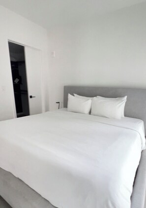 Ein Schlafzimmer mit Bett, Tür und Schrank.