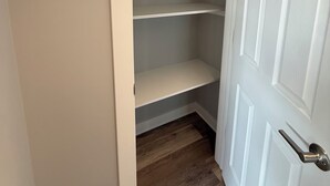 A closed door with a white handle, a wooden floor, and a white wall. - Fully Renovated 1BR  Walk to Hospitals University Parking (Indianapolis)